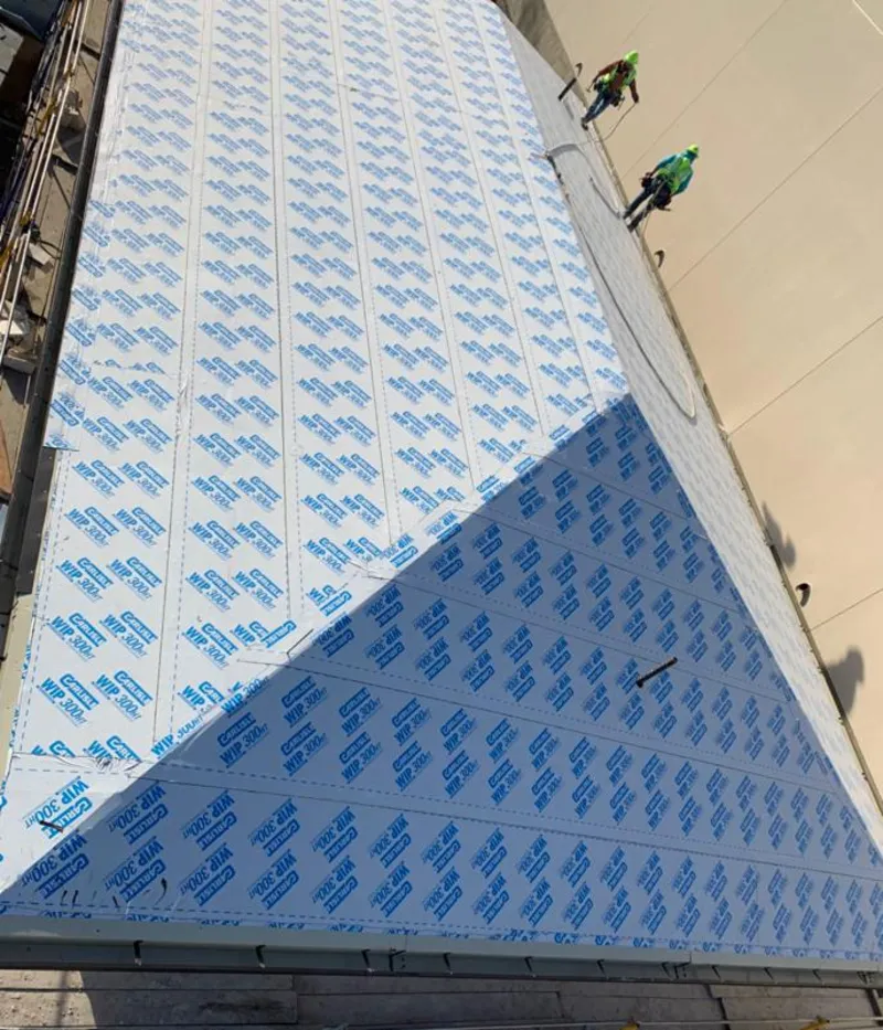 Professional roofers installing underlayment on a metal roof in Balm